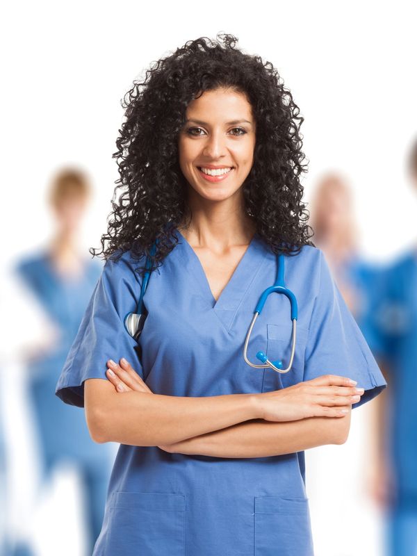 Nurse with curly brown hair smiling at the camera