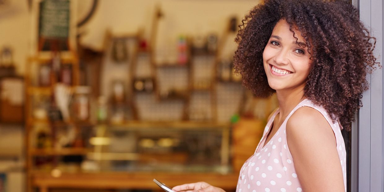 african american lady in pink holding a tablet