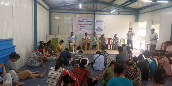 Community gathers for a human trafficking awareness campaign in a modest hall.