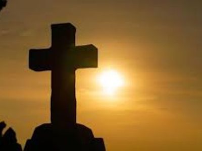 Silhouette of a cross at sunset.