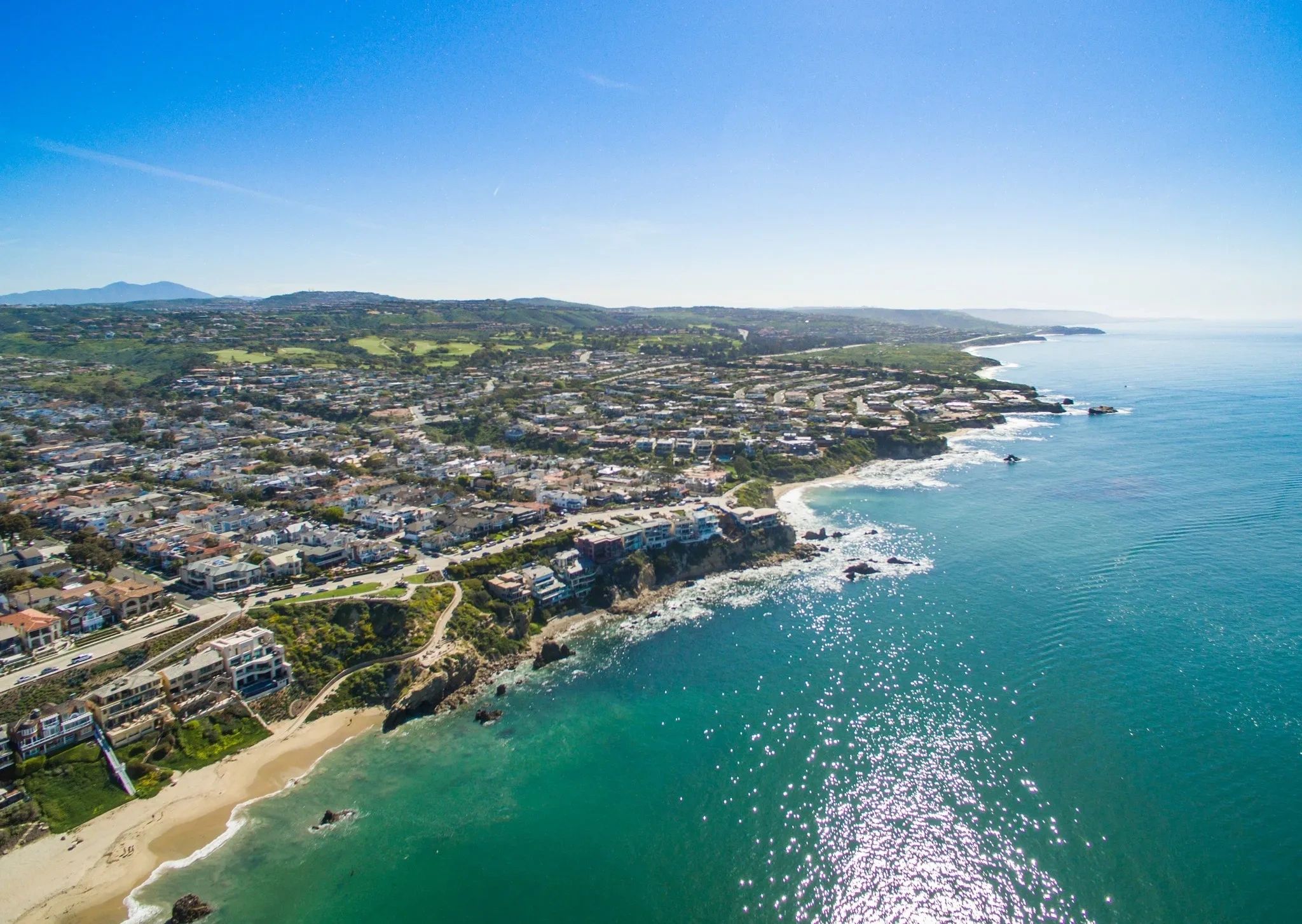 Aerial view of a coastal city with clear blue skies and ocean.