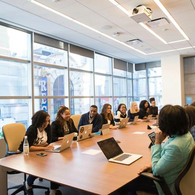 people at a meeting table with laptops