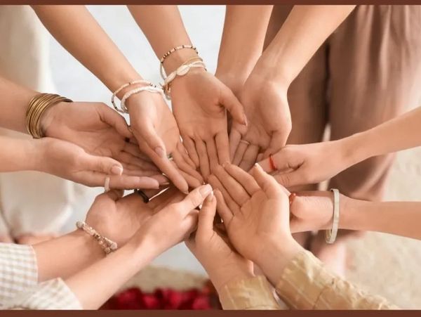 Multiple hands joined together in a circle, symbolizing unity and support.