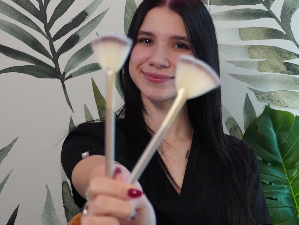 Licensed Esthetician in Las Vegas holding facial brushes.