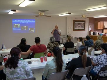 Community gathering with a speaker presenting to an audience.