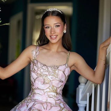 Young woman in elegant dress and tiara smiling.