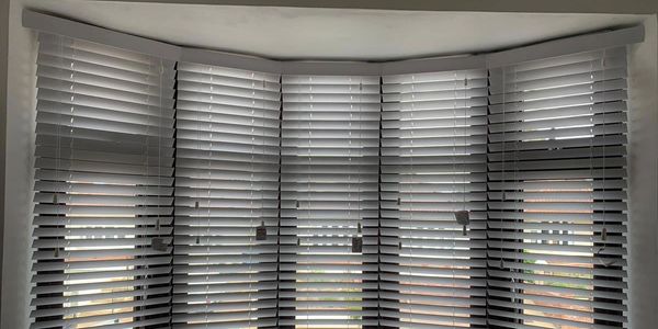 small and vertical venetian blinds fitted on a curved bay window in Warwickshire.