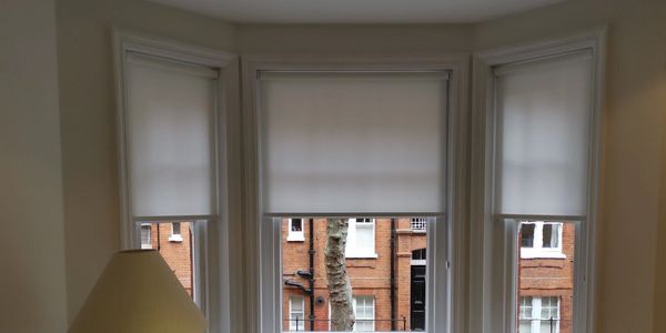 Roller blinds fitted in a bay window looking onto the street of leamington spa