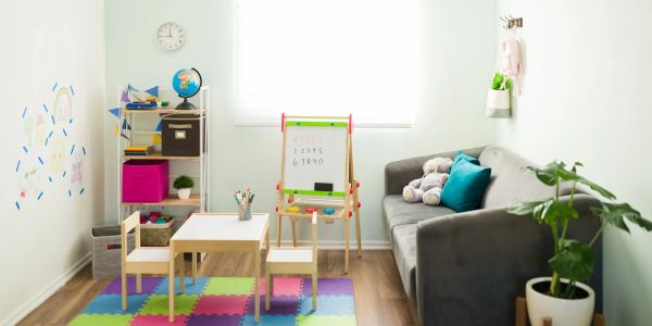 Bright children's playroom with colorful mat, small table, and educational toys.