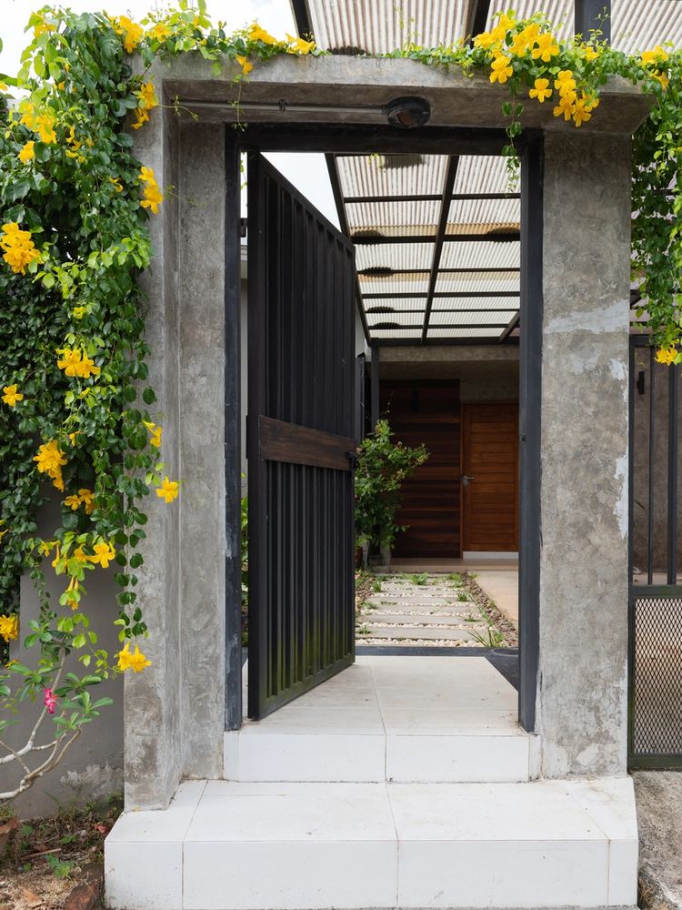 Entrance gate with yellow flowers and tiled steps.