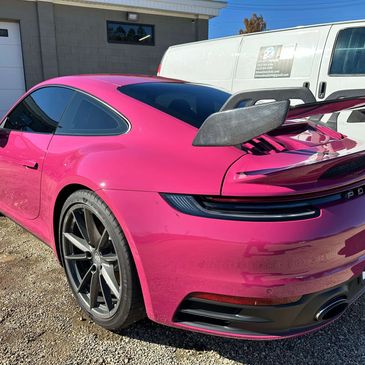 Bright pink Porsche 911 with carbon fiber wing after full professional detail in Greenville NC