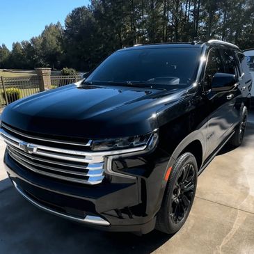 Black Chevrolet Tahoe SUV freshly polished and ceramic-coated, parked in driveway after detailing.
