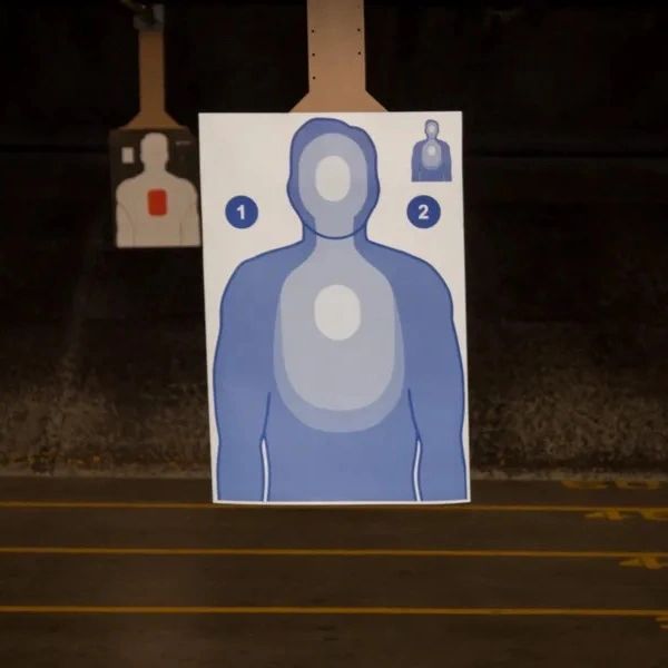 Shooting range with human silhouette targets in blue and white markings.