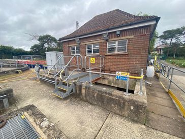 Small brick utility building with metal railings and stairs.
