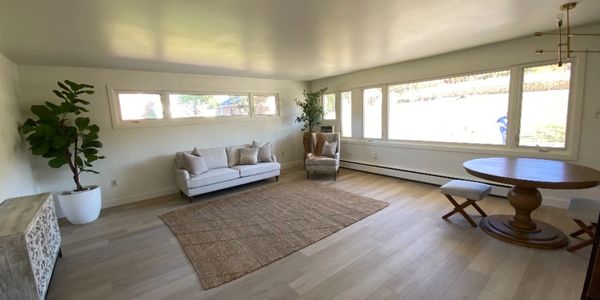 Spacious living room with minimalist furniture and large windows.