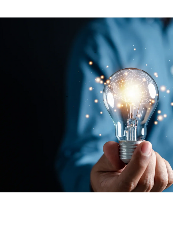 Person holding lightbulb radiating sparks of ideas