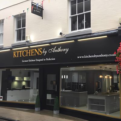 Exterior of "Kitchens by Anthony" German kitchen showroom with black and gold signage.








