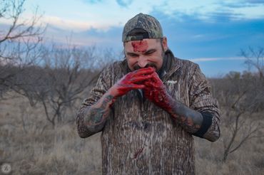 Man with blood on his hands in outdoors.