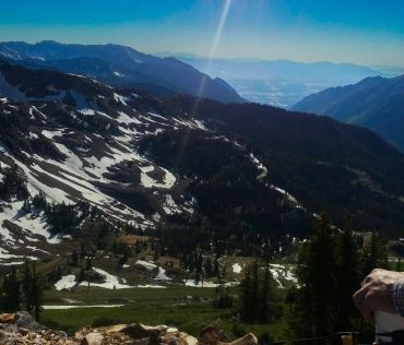 Mountain landscape with snow patches and clear blue sky.