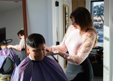 A man getting a haircut at a barbershop.