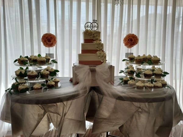 Tiered wedding cake and cupcakes