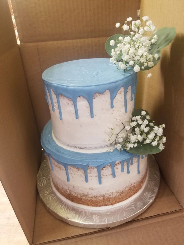 Blue drip and greenery two tiered wedding cake