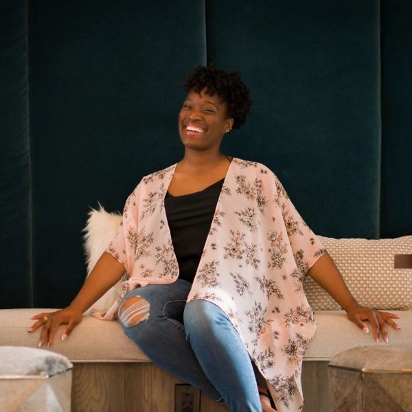 Woman smiling happily while sitting on a couch.
