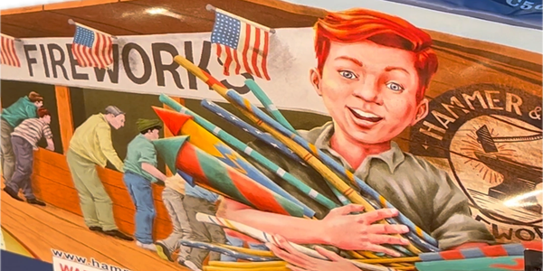 An illustration of a young boy walking away from the fireworks stand near-by while cradling two arms