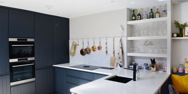 Jenny Sheahan's kitchen with a peg rail, hanging pots and pans, and sliding pocket pantry doors