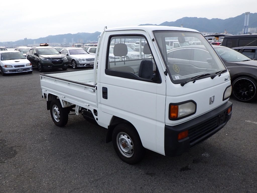 Honda Acty truck displayed with a factory service manual offered by OIWA for customer insight.