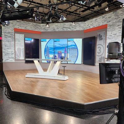 Empty news studio set with cityscape screen.