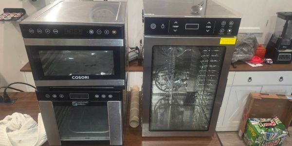 Two stainless steel kitchen appliances on a wooden counter.