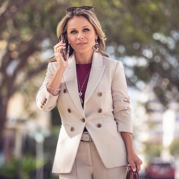 Paula McCabe the Realtor holding a briefcase while talking to a client on the phone in Sarasota FL