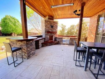 Outdoor kitchen and fireplace with bar