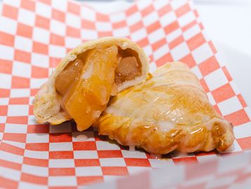 Two apple turnovers on checkered paper.