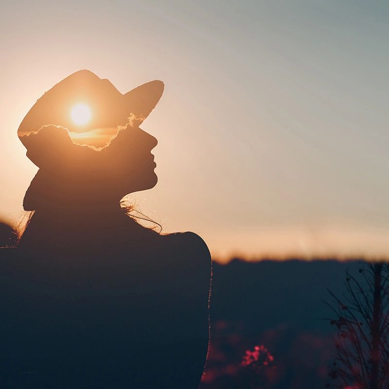 Silhouette at sunset symbolizes mental clarity and relief offered by BrainsWay's dTMS treatment.