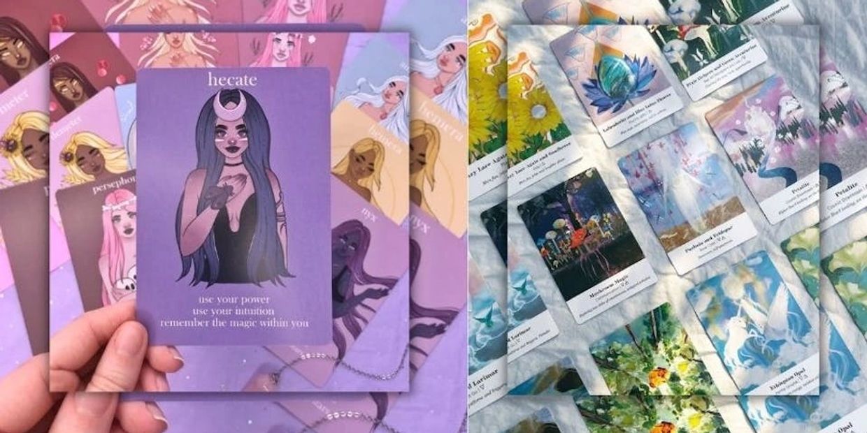 Hand holding a purple tarot card with mystical illustrations and messages, surrounded by other colorful tarot cards.