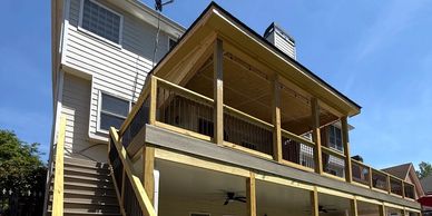 Two-story house with a wooden deck and stairs.