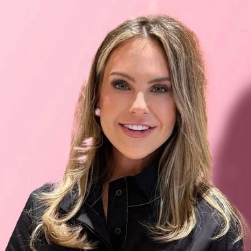 Smiling woman with blonde hair against a pink background.