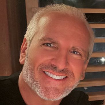 Smiling man with gray hair and beard.