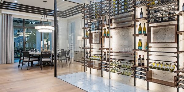 Modern dining room with glass-enclosed wine storage.