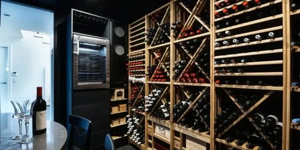 Wine cellar with wooden racks holding numerous wine bottles.