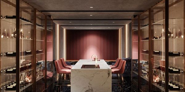 Luxurious wine cellar with marble island and pink chairs.