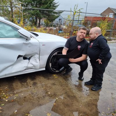 Grado and Chris Toal assesing a vehicle involved in a non fault accident.