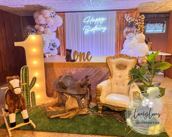 Western-themed first birthday party setup with gold accents and cowboy decor.