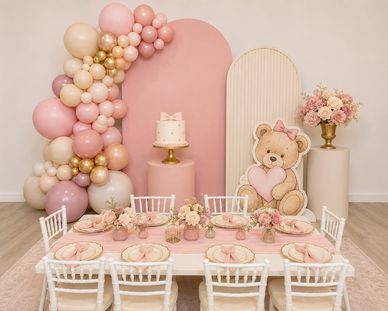 Pink-themed party setup with teddy bear and balloons.