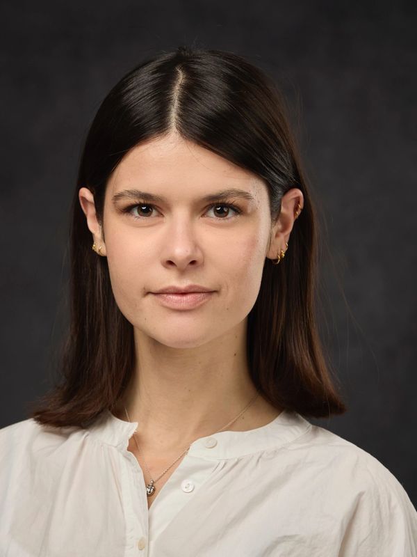 Portrait of a woman with dark hair against a dark background.