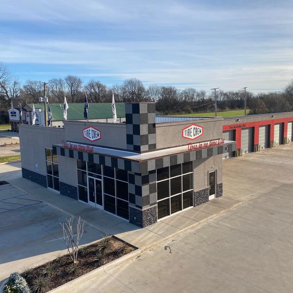 Modern Tire Crew service center with multiple bays and checkered design.