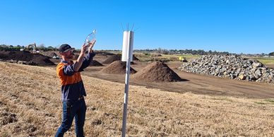 Field technician inspecting contents of dust bottle sampled from adjacent dust guage