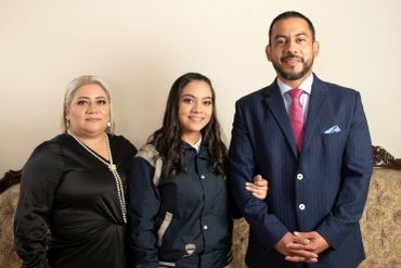 Family portrait with three people posing indoors.